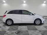 the white mercedes b - class is parked on a checkered floor