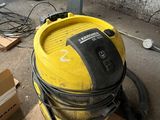 a yellow vacuum sitting on the floor next to a box