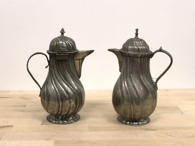 pair of antique silverplated coffee pots on a wooden table