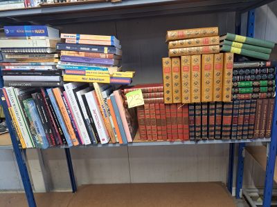 de nombreux livres empilés sur une étagère métallique dans une pièce