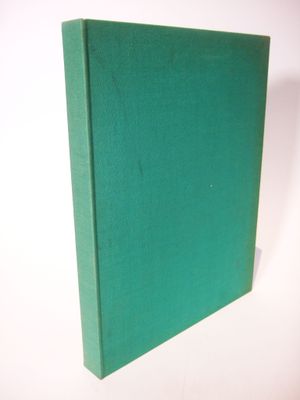 the green book is sitting on a white surface