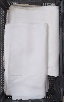 un panier contenant une pile de serviettes blanches