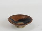 brown and black bowl on a white surface