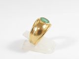 a close up of a gold ring with a green stone in it