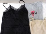 two women ' s pajamas and a tote bag are laying on a bed