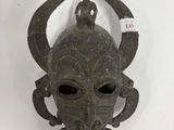 une image montrant un gros plan d'un masque accroché au mur