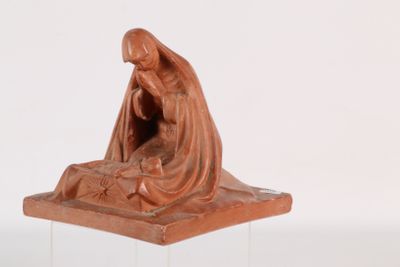figurine of a woman kneeling on a rock with a baby jesus in her lap