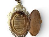 a gold locke with a picture in it on a white surface