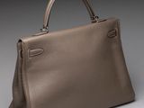 a brown leather handbag sitting on top of a gray surface