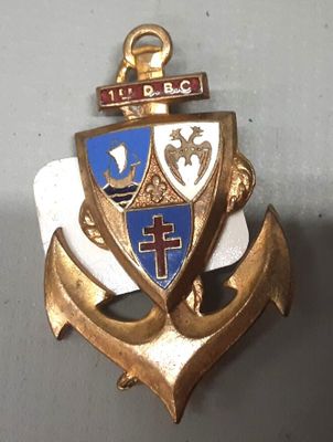une ancre dorée ornée d'une croix et un blason bleu et blanc
