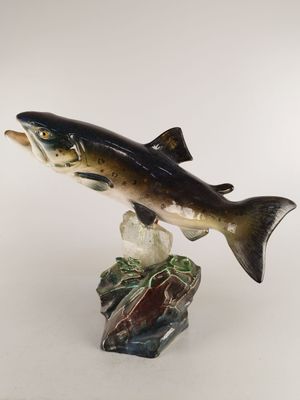 figurine représentant un poisson posé sur un rocher, sur fond blanc
