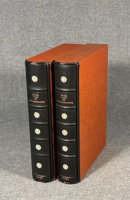 two books sitting on top of each other on a gray surface