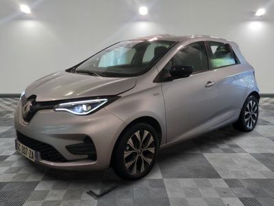 une voiture argentée garée dans une pièce au sol en damier
