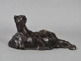 bronze sculpture of a dog laying down on a gray surface