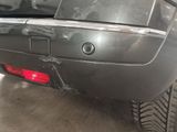 the rear end of a car with a dented bumper