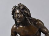 bronze statue of a man playing a guitar on a marble base