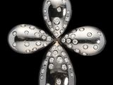 un gros plan d'une croix en argent et diamants sur fond noir