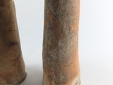 two vases sitting next to each other on a white surface