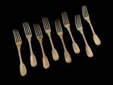 six forks are arranged in a row on a black background