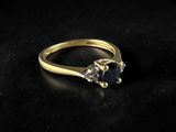 a close up of a gold ring with a black diamond