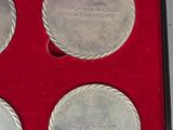 four silver coins are in a red box on a table