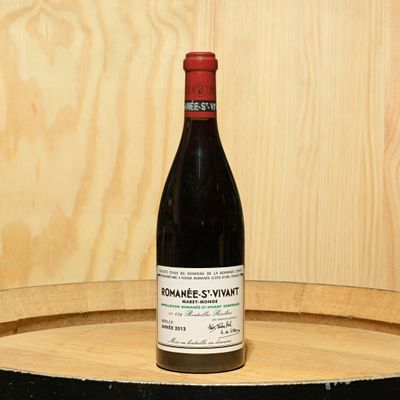 a bottle of wine sitting on top of a barrel
