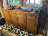 une table de buffet en bois sur laquelle sont posées des assiettes et des bols