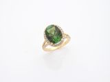 un gros plan sur une bague en tourmaline verte et diamants