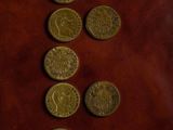 a bunch of coins sitting on top of a brown leather surface
