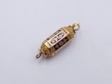 a small gold and blue glass bead on a white surface