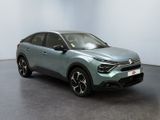 a grey car is parked in a room with a white wall