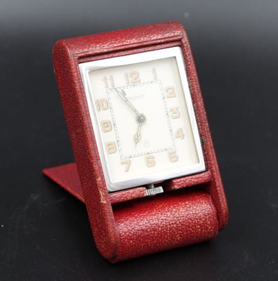 an image of a small red watch sitting on top of a black table