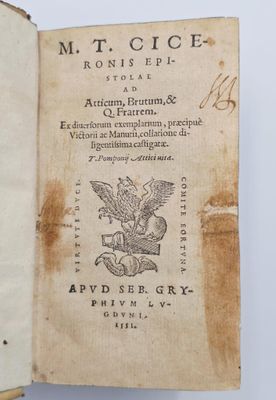 un vieux livre sur lequel est représenté un oiseau, posé sur une table