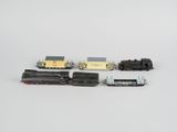 quatre types différents de petits trains posés sur une surface blanche