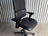 an image of a black office chair in front of a corrugated wall