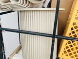 a metal rack with a yellow basket and a pile of blankets