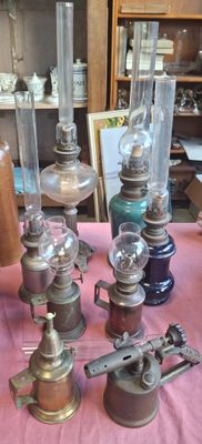 beaucoup de vieilles lampes posées sur une table recouverte d'une nappe rose