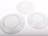 three white plates sitting on top of each other on a white surface