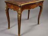 une petite table avec un plateau en bois et des ornements dorés sur les pieds