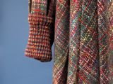 a close up of a coat hanging on a clothes rack