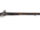 un vieux fusil avec un canon en bois et des garnitures en laiton