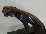 bronze statue of a panther on a black marble base