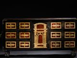 une commode noire et dorée surmontée d'une horloge
