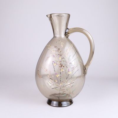 un pichet en verre orné d'un motif floral
