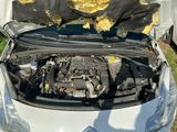a white car with a broken hood and a black bag on it
