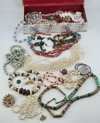 a red box filled with lots of assorted beads and necklaces