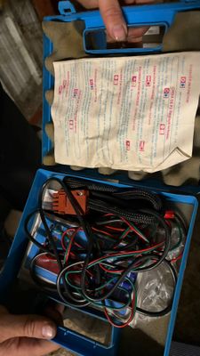 une personne tenant une boîte bleue remplie de fils