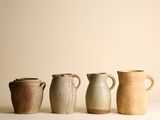 Plusieurs vases de différentes tailles sont alignés sur une surface blanche