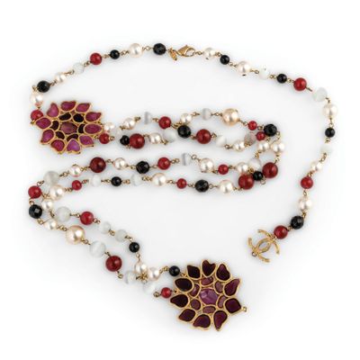 a close up of a necklace with pearls and red and black beads