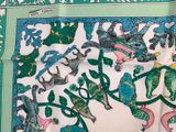 a green and white scarf with birds and flowers on it